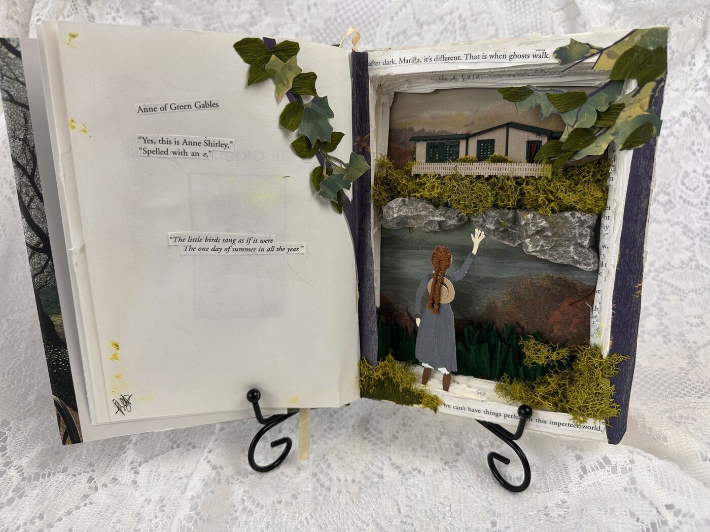 Anne of Green Gables book diorama, paper Anne waving toward Green Gables across moss, rock, and book-text borders