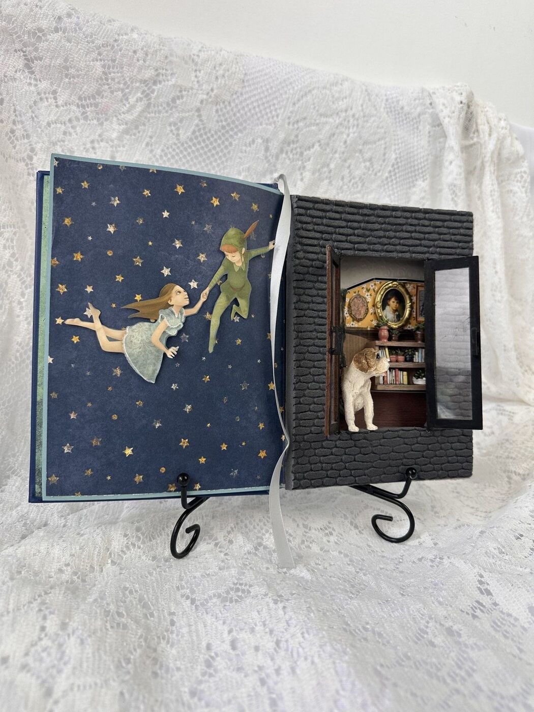 Peter Pan book diorama, Wendy and Peter flying through a starry night on the left page, a brick nursery window with Nana the dog looking in on the right
